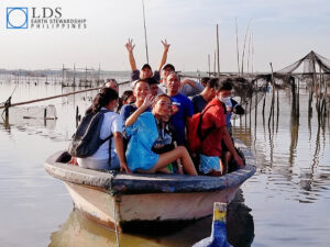 Members use boats to plant mangroves