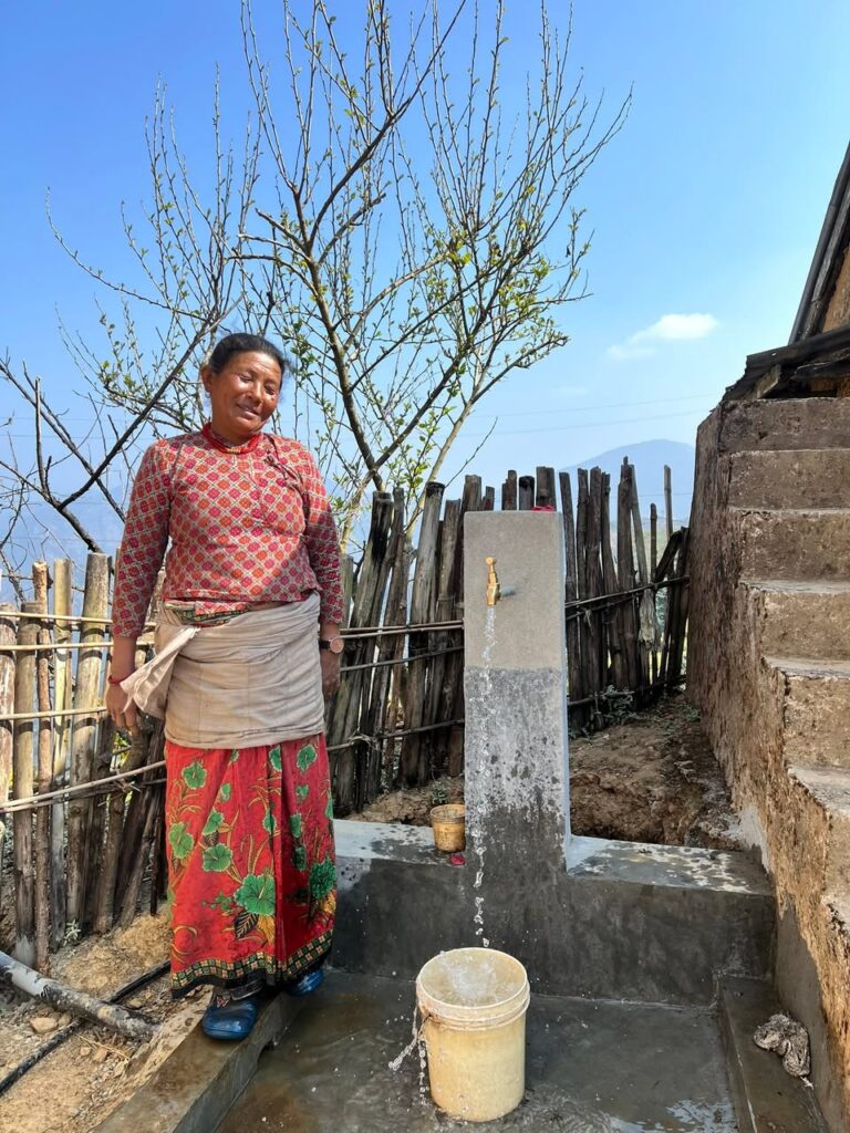 A Nepalese woman by her water supply system.